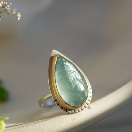 Scintillating aquamarine sparkling in a silver ring with gold-fill detail.