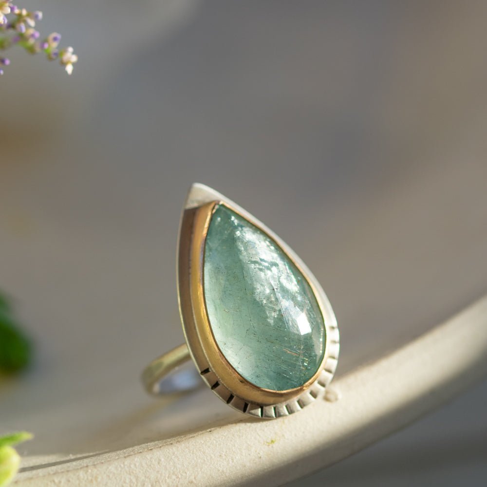 Scintillating aquamarine sparkling in a silver ring with gold-fill detail.